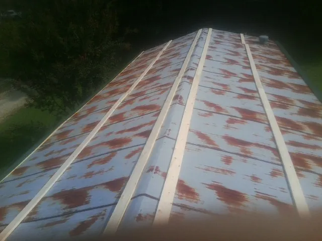 Rusted metal roof panels with new wood purlins before replacement — Storm Damage Roof Repair in Falmouth by Roofing Brothers